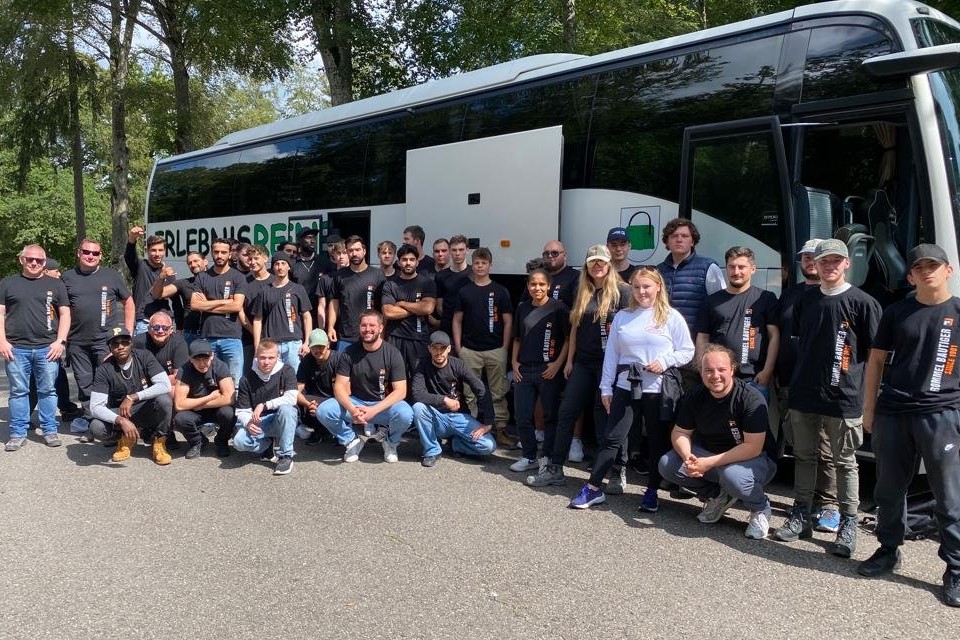 Foto: Gruppe Auszubildende vor Reisebus.