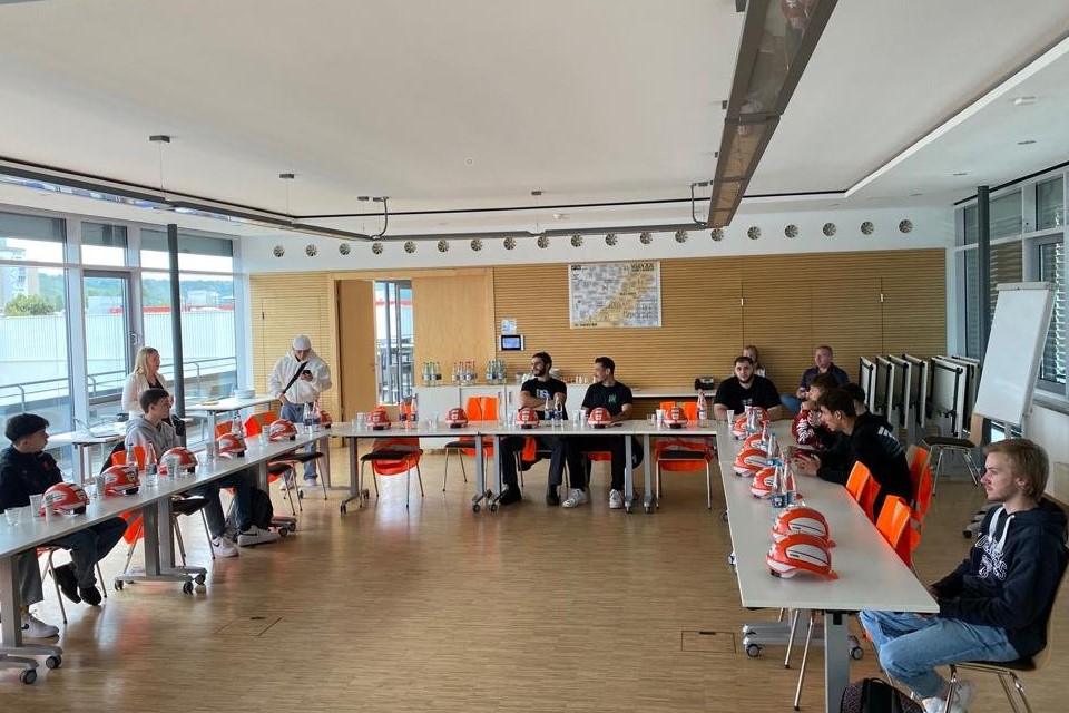 Foto: Azubis im Seminarraum mit Helmen auf den Tischen.